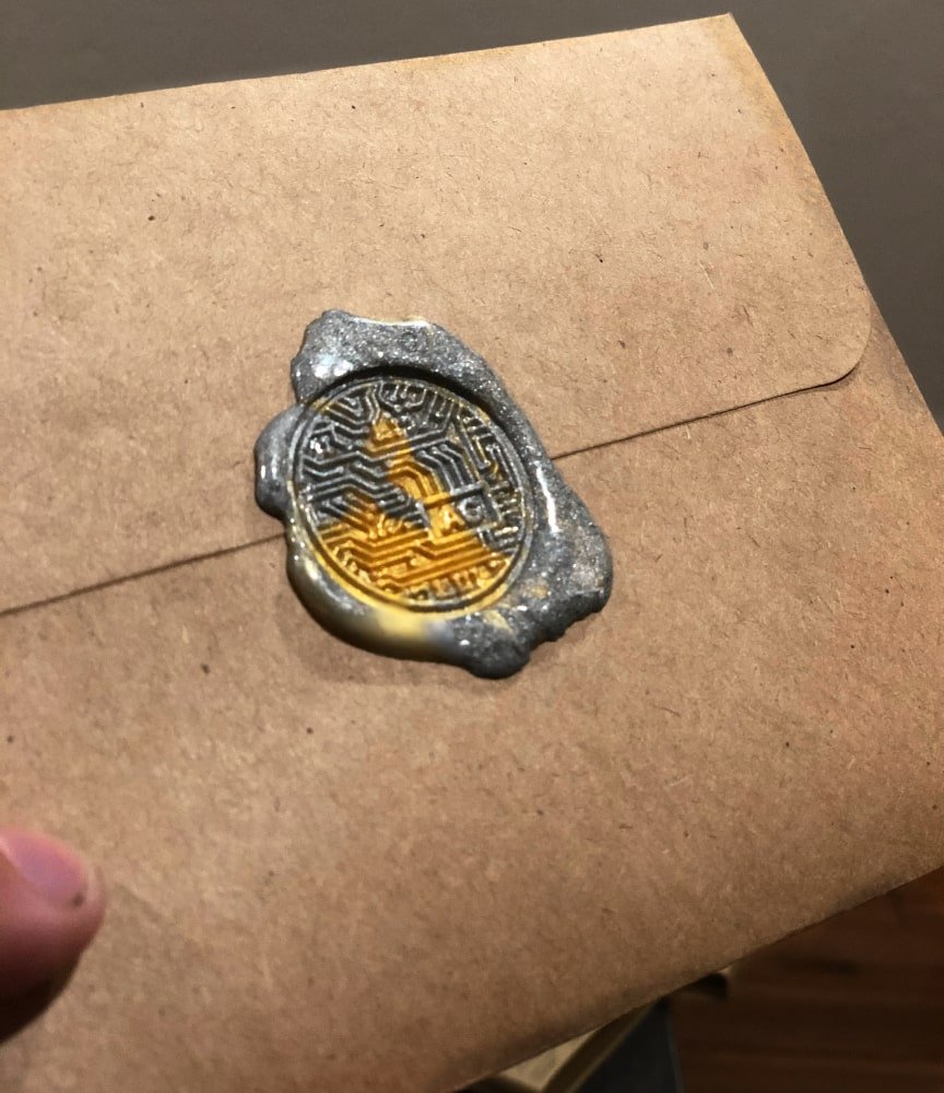 An envelope stamped with my wax seal, with a combination of gold and silver wax.